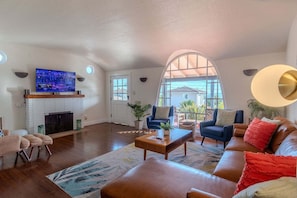 Ein Wohnzimmer mit Kamin, Fernseher, Sofa und Couchtisch.