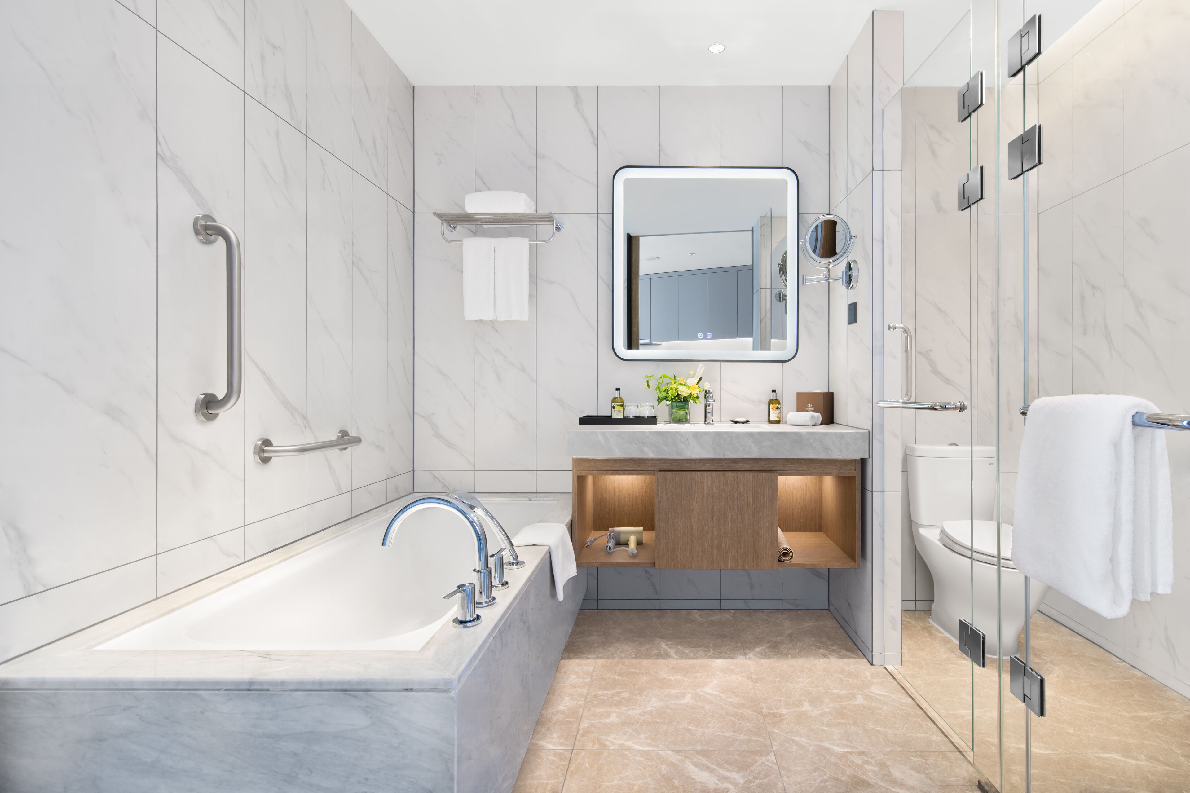 Une salle de bain moderne avec une baignoire, un meuble-lavabo avec un miroir et un espace douche.