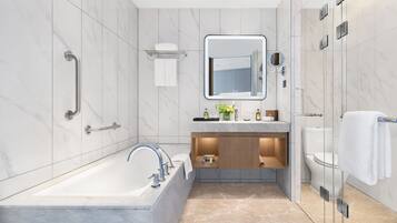 Une salle de bain moderne avec une baignoire, un meuble-lavabo avec un miroir et un espace douche.
