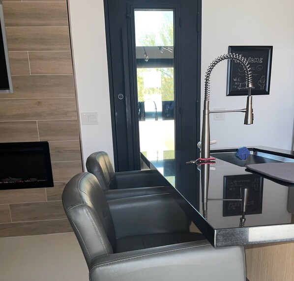 Una cocina moderna con una isla de vidrio, un banco empotrado y una pizarra con escritura.