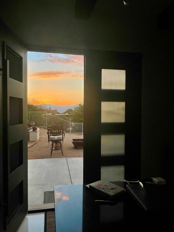 A room with a view of a sunset over a balcony.