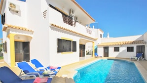 A poolside area with lounge chairs and a swimming pool.
