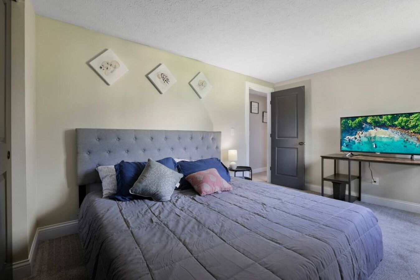 Ein Schlafzimmer mit einem Bett, einem Fernseher und einer Tür.