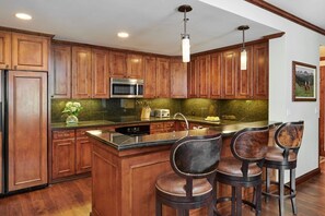 Enjoy cooking in this well-equipped kitchen with a central island, sink, and microwave, plus ample seating for two at the bar.