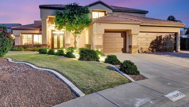 A two-story house with a garage, a well-maintained lawn, and a driveway. - Extravagant Backyard & Dazzling Interior Concepts (Scottsdale)