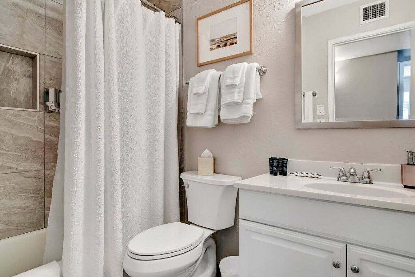 A bathroom with a shower, toilet, and sink.