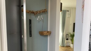 Un pasillo con piso de madera, una cesta colgante y un letrero que dice "beach".