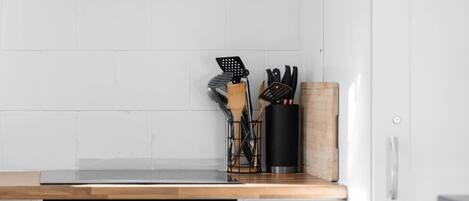A kitchen with white cabinets, a stainless steel oven, and a wooden countertop.