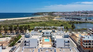 Hotel à beira-mar com piscina no terraço, vista para a praia e acesso ao porto.