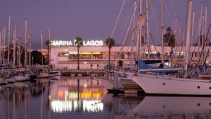 Uma marina com vários barcos atracados, um edifício com a inscrição 