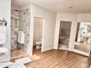 A modern bathroom with a marble shower, a toilet, a sink, and a large mirror. - 42-Resort Condo, Pool, Hot Tub, Pickle-ball, Gym. (St. George)