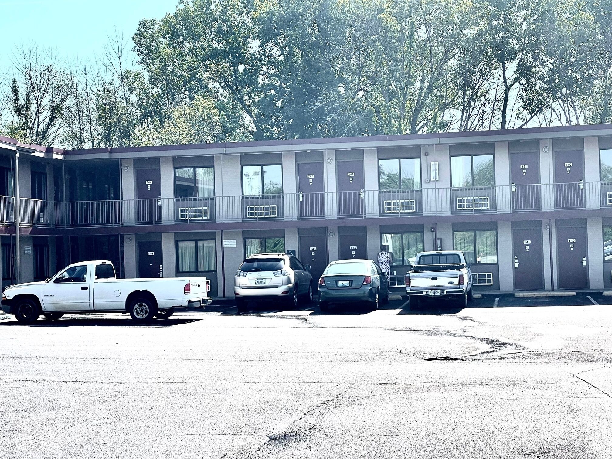A motel with multiple parking spaces and a two-story building with balconies.