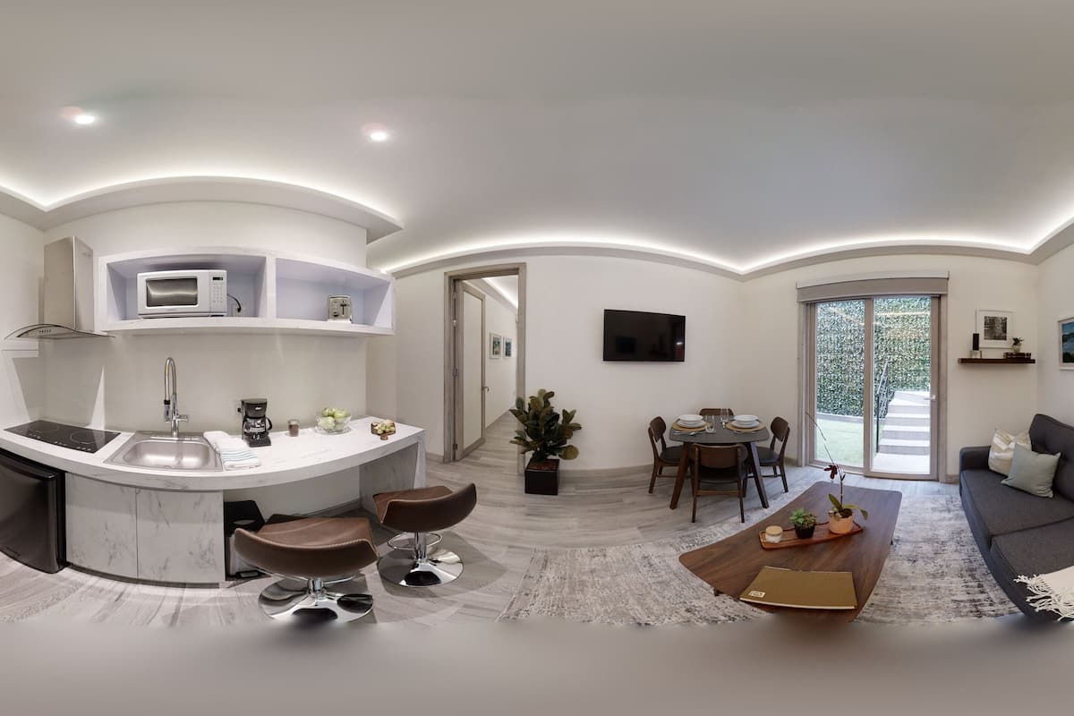 A modern kitchen with a built-in microwave, a dishwasher, and a dining area with a table and chairs.