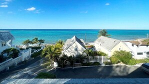 Zona residencial costera con casas, cielo azul despejado y vista al océano.