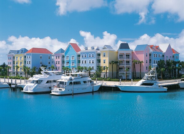 A marina with colorful buildings and yachts docked.