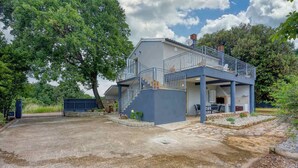 A two-story house with a balcony, a staircase, and a patio area. - Apartment Mirjana for two people, quiet location, barbecue, pets welcome (Fažana)