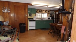 Un espacio habitable compacto con kitchenette, comedor y sofá.