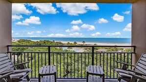Een balkon met uitzicht op het strand en de oceaan.