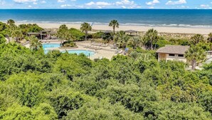 Een resort met zwembad, strand en uitzicht op de oceaan.