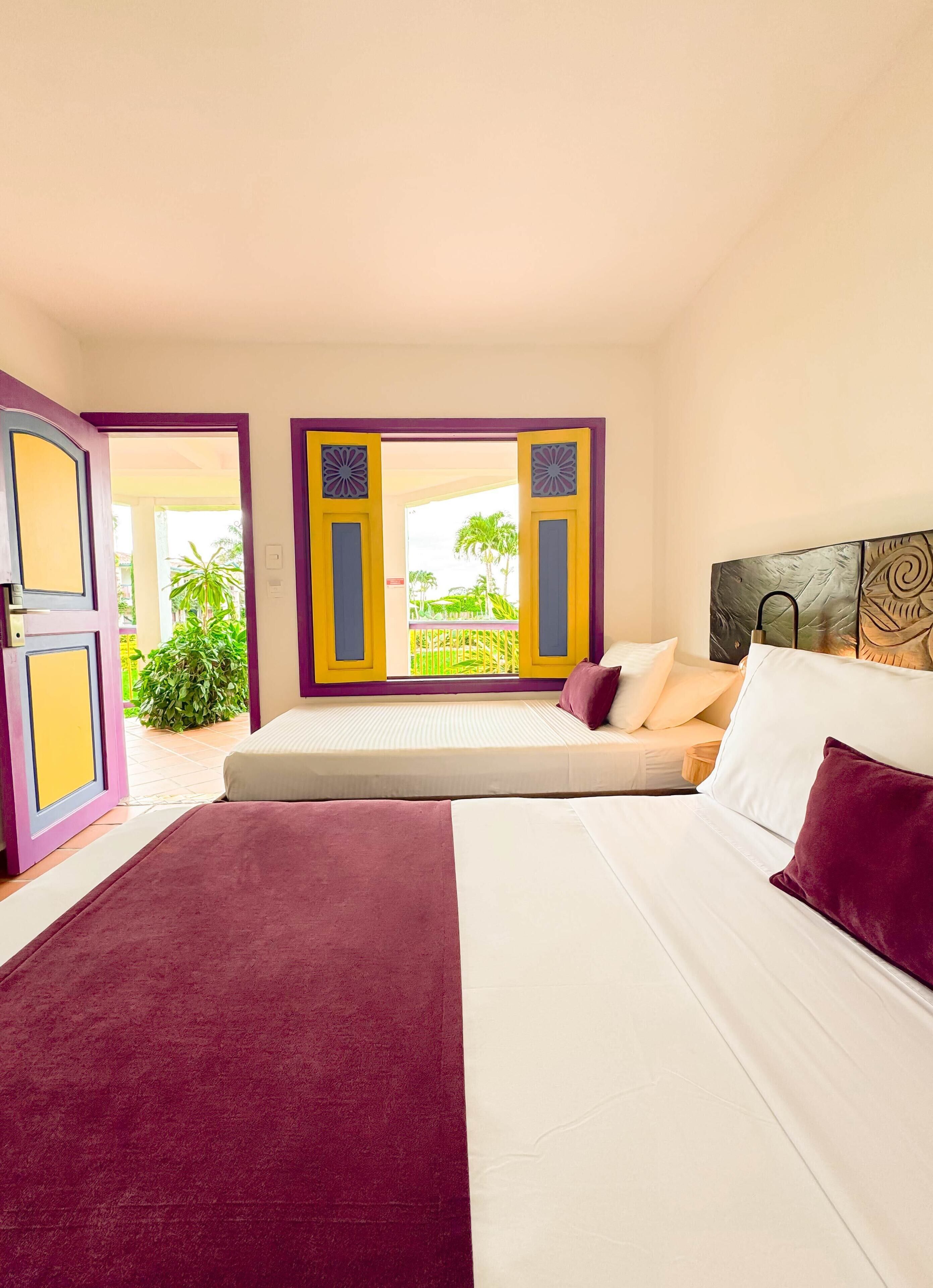Un dormitorio con cama, vistas al exterior y una puerta que da al exterior.