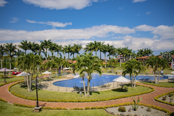 Una piscina al aire libre, sombrillas, sillones reclinables de piscina