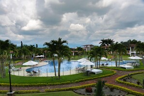 A resort with a central swimming pool, palm trees, and lounge chairs. - Hotel Campestre Café Café (Montenegro)