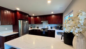 Una cocina moderna con armarios de madera oscura, electrodomésticos de acero inoxidable y encimera de mármol.