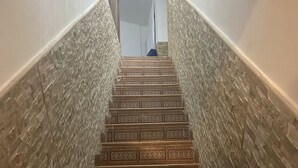 A staircase with patterned steps and textured walls.
