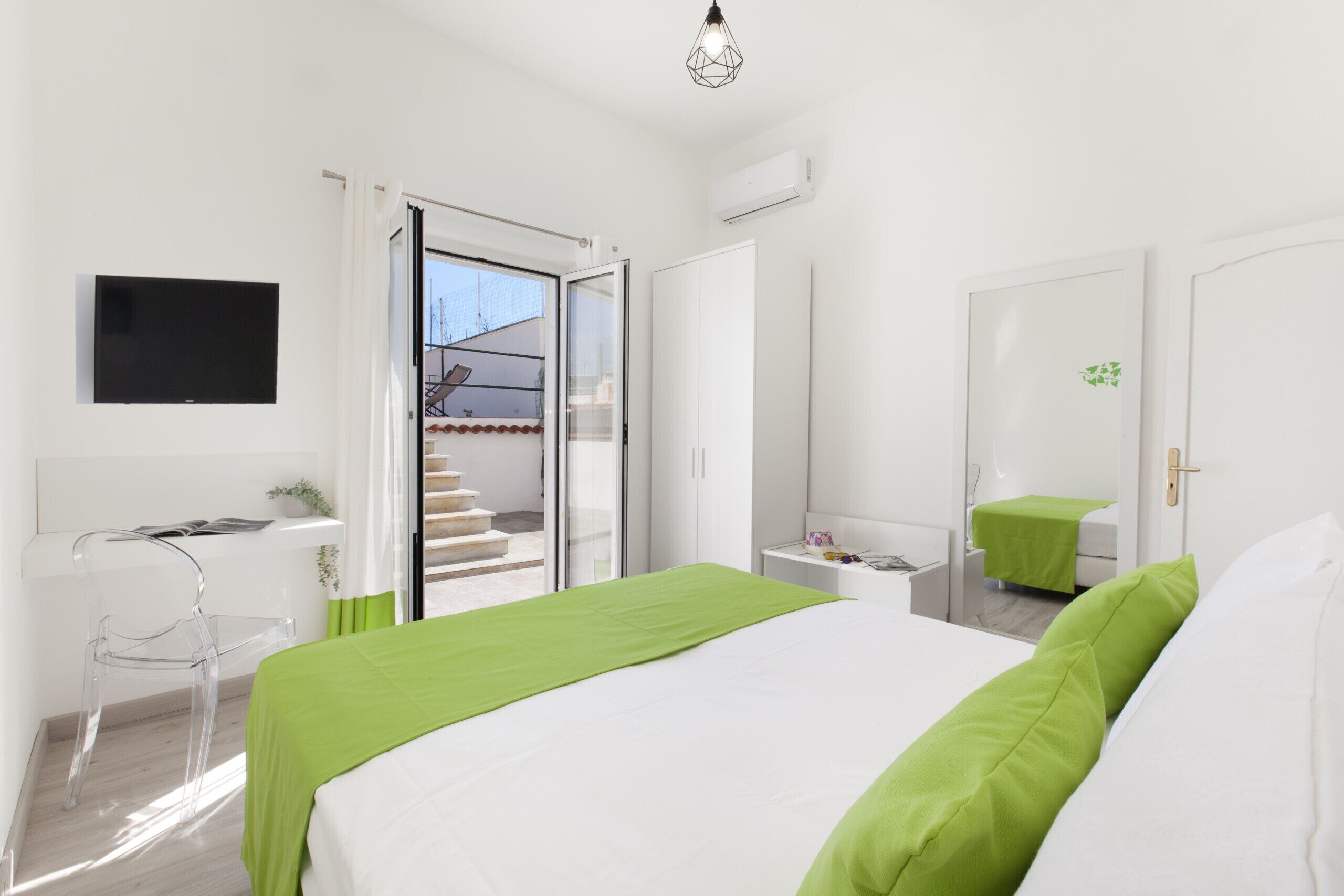 Une chambre à coucher moderne avec un lit, un bureau et un téléviseur.