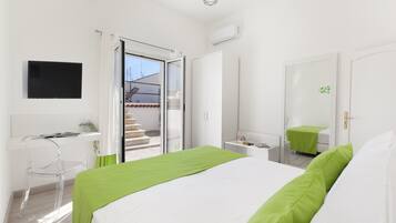 Une chambre à coucher moderne avec un lit, un bureau et un téléviseur.