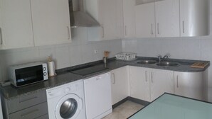 A compact kitchen with white cabinets, a built-in microwave, a dishwasher, and a sink. - VuT Rupurupay A (Aldeadávila de la Ribera)