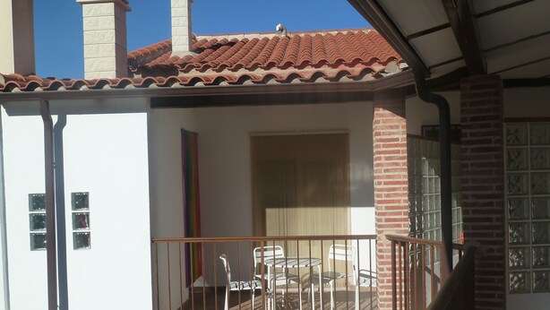 A residential building with a tiled roof, a balcony with a metal railing, and a brick wall. - VuT Rupurupay A (Aldeadávila de la Ribera)