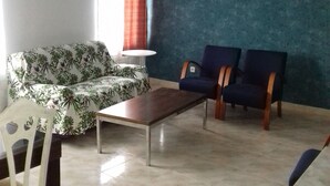 A living room with a sofa, two chairs, a coffee table, a painting of an eagle, and a window with curtains. - VuT Rupurupay A (Aldeadávila de la Ribera)