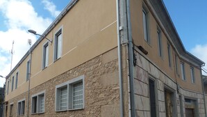 A corner building with a stone facade, multiple windows, and a visible entrance. - VuT Rupurupay A (Aldeadávila de la Ribera)