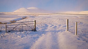 A snow-covered landscape with a metal gate and wooden posts. - Charming Stone Parlour Cottage set in an area of outstanding beauty. (Biggar)