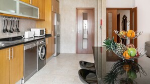 A modern kitchen with wooden cabinets, stainless steel appliances, and a fruit bowl on the counter. - Solange' Place - 300 metres from Nazaré Beach (Nazaré)