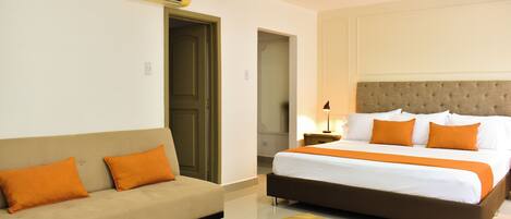 A hotel room with a bed, a sofa, and a coffee table.