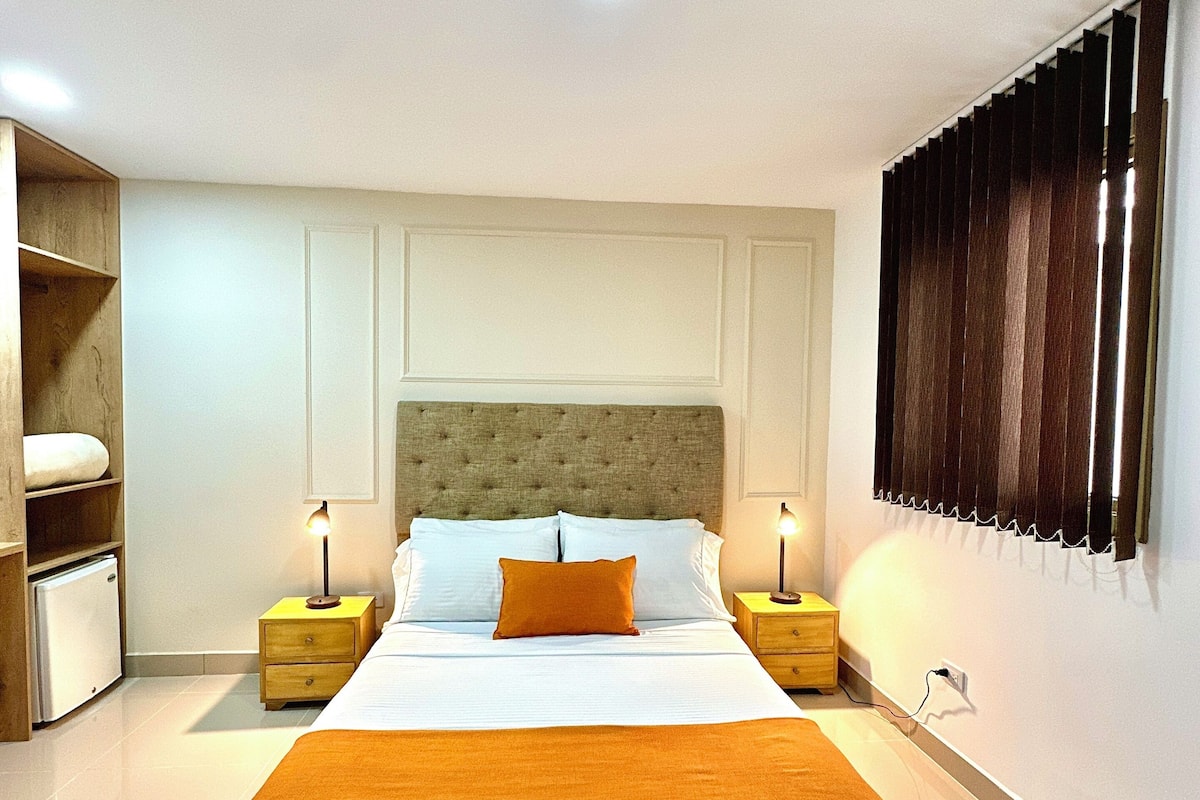 A modern bedroom with a large bed, two bedside tables, a wardrobe, and a built-in shelf unit.