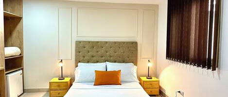 A modern bedroom with a large bed, two bedside tables, a wardrobe, and a built-in shelf unit.