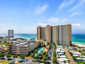 A high-rise hotel with multiple floors, a swimming pool, and a beach view. - Gulf-Front 1 Bed, 2 Bath • Sleeps 6 • Amenity-Packed • Beach Chair Service for 2 (Panama City Beach)