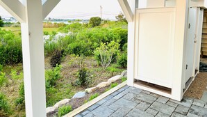Un espacio al aire libre techado con vistas a un paisaje natural, que incluye un cuerpo de agua y vegetación.
