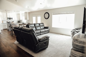Relax in a spacious living area with a large sofa, armchairs, and a dining table.