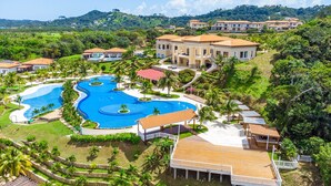 A resort with a large central pool, multiple villas, and lush greenery. - Pristine Bay Villa 1304  with large pool - 3 bedroom (Roatan)
