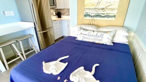 Un dormitorio con cama, almohadas y un cuadro en la pared.
