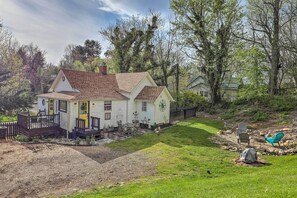 Ein einstöckiges Haus mit Veranda, kleiner Terrasse und gepflegtem Rasen.