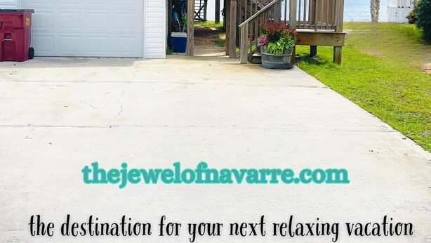 A two-story house with a covered porch and a garage. - Navarre Beach Front Whole House Large Yard. Kayaks + Paddle Boards Included.  (Navarre)