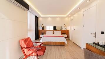 Ein modernes Hotelzimmer mit einem großen Bett, einem Schreibtisch mit Stuhl, einem Schminktisch mit Spiegel und einem großen Fenster.