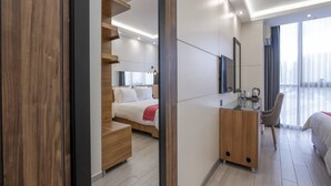 A modern hotel room with a bed, a desk, and a chair. There is a staircase leading to an upper level. - Maa Hotel and Suites (Nairobi)