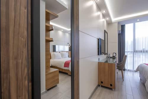 Habitació doble superior, 1 llit de matrimoni, vistes a la ciutat | Sala d'estar | Televisor intel·ligent de 42 polzades amb canals per satèl·lit