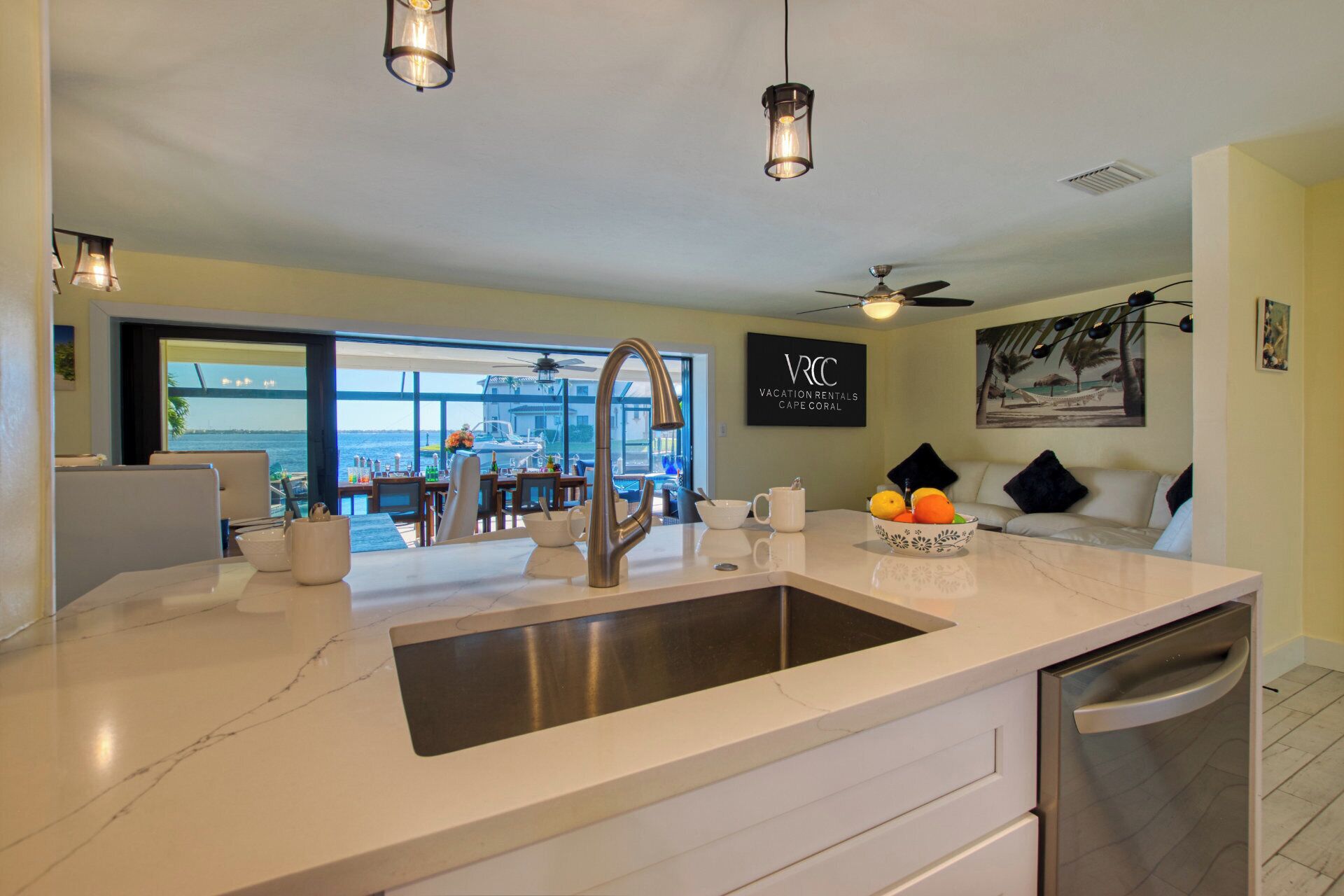 A modern kitchen with a large island, a view of the sea, and a dining area with a view.